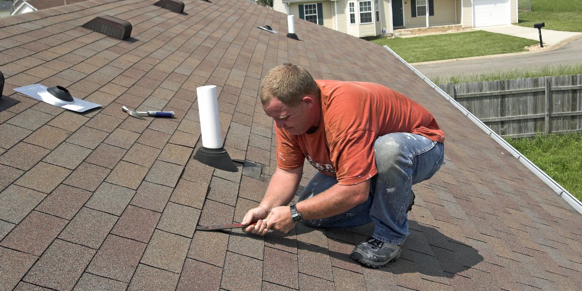 Man replacing and repairing the roof of a house